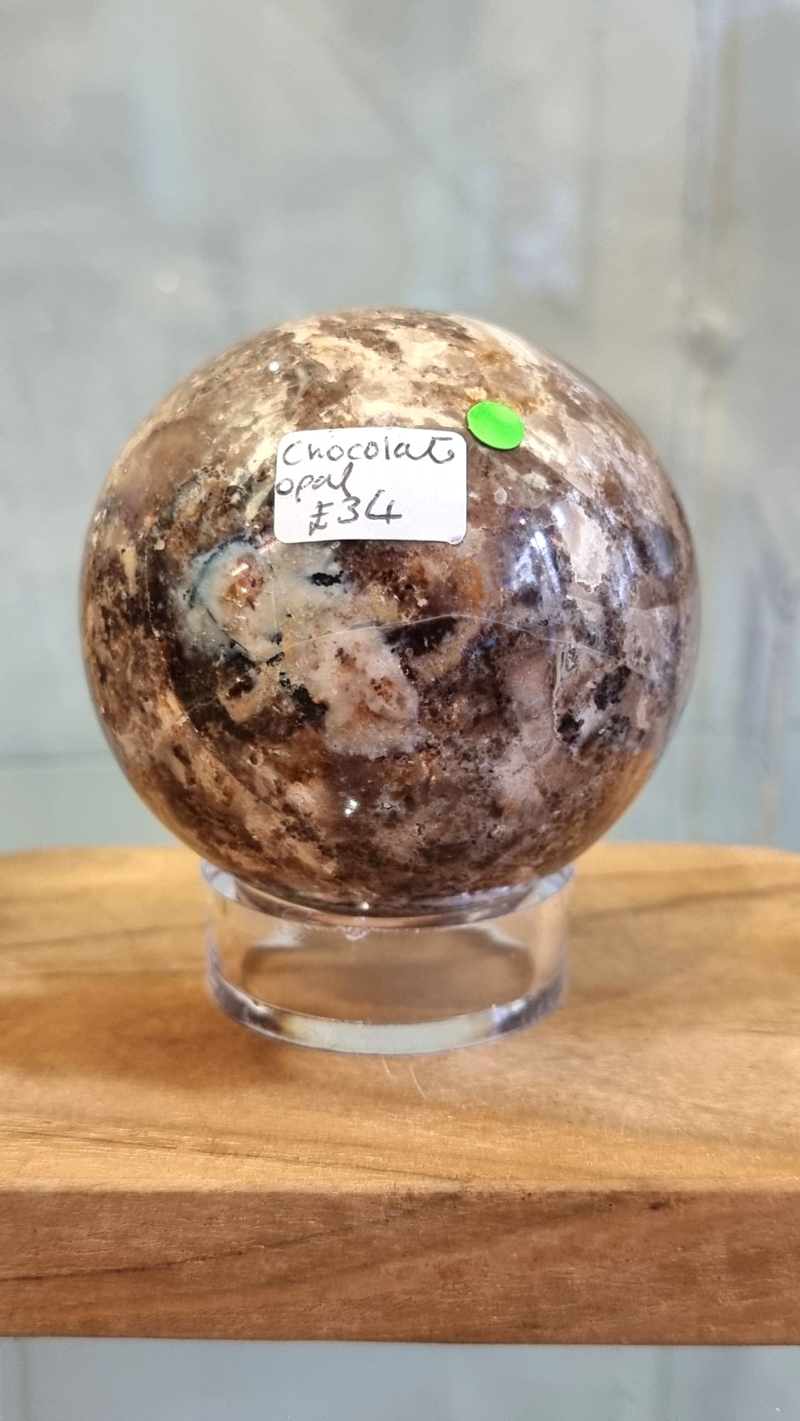 Nurturing and grounding, a chocolate opal crystal sphere with stand.