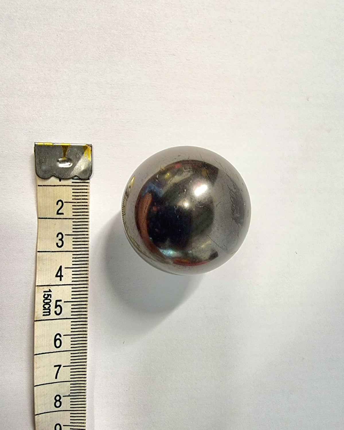 A polished shungite sphere with clear acrylic stand great for absorbing electromagnetic smog.