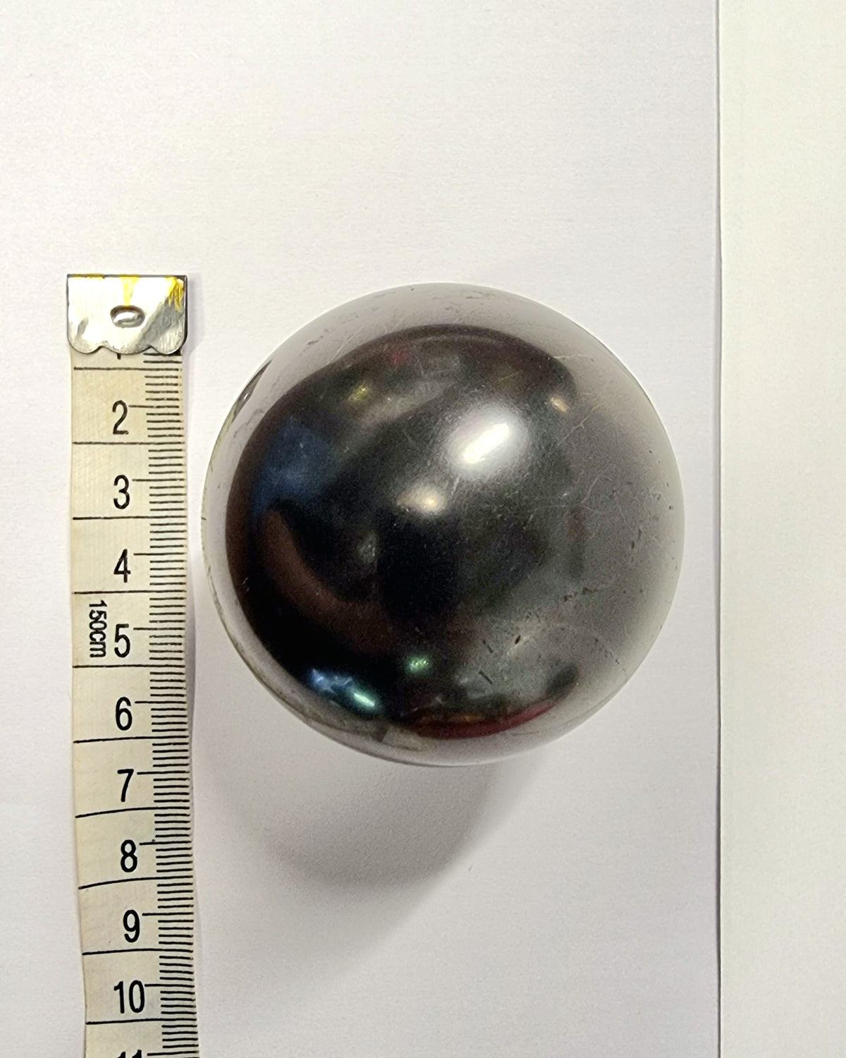 Polished shungite sphere used to absorb negative energy and electromagnetic fog.