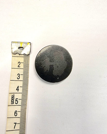 A sticker made from black shungite with a Tree of Life symbol etched into it.  Used to attach to electronic devices to absorb EMF.