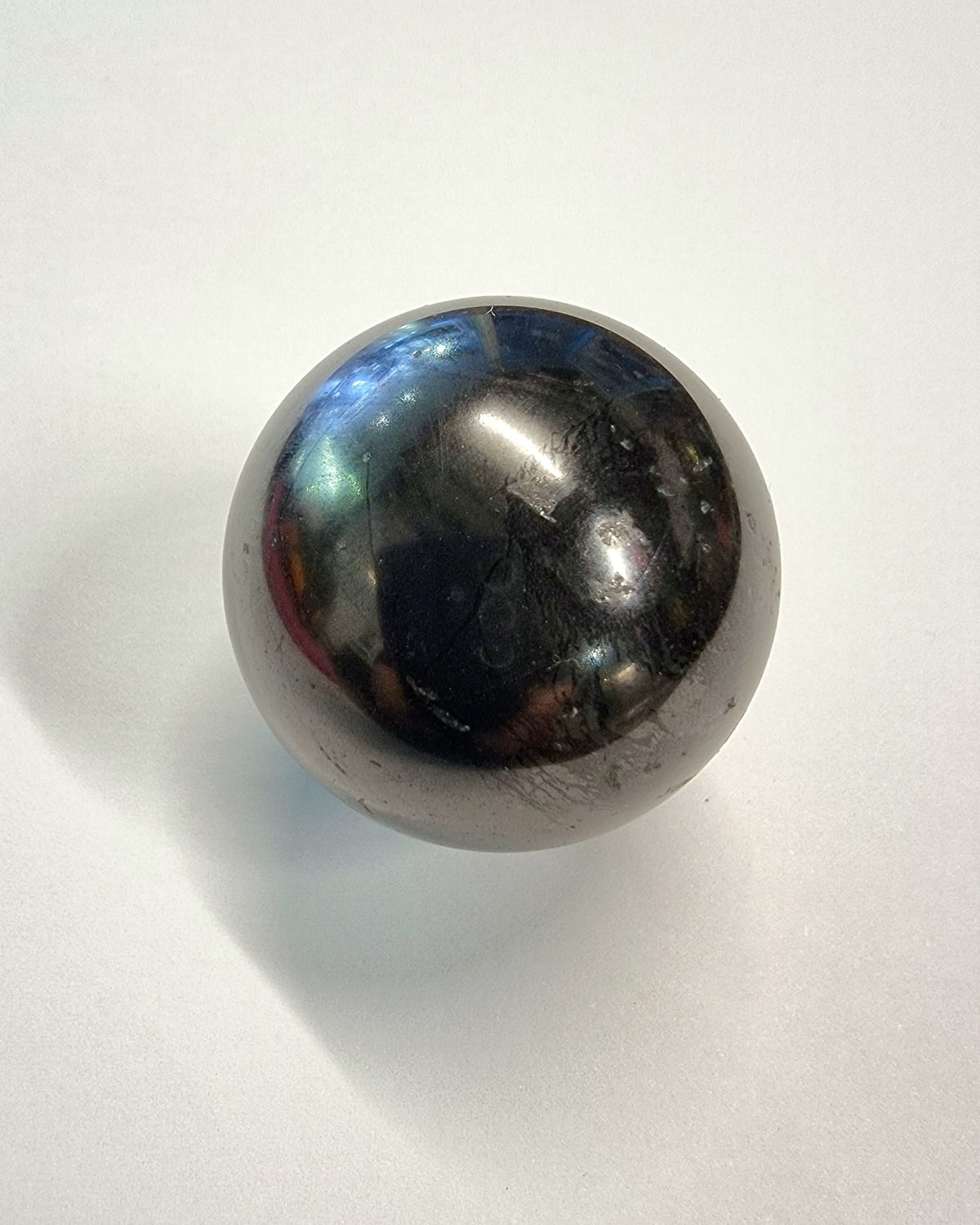 A polished shungite sphere with clear acrylic stand great for absorbing electromagnetic smog.